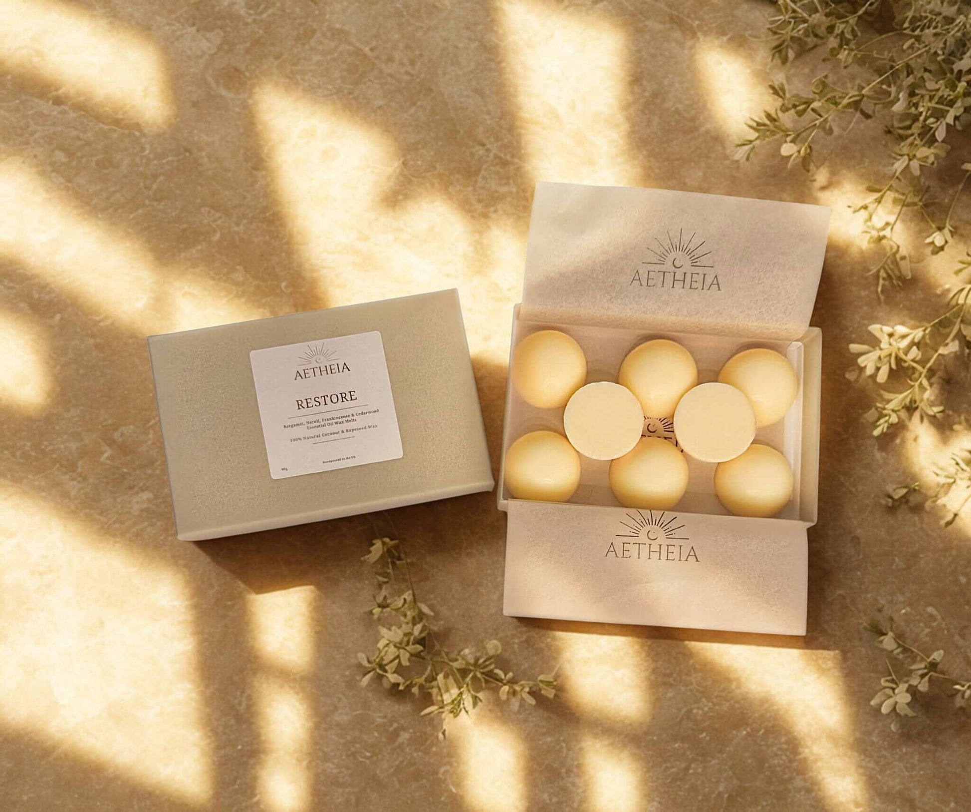Aethelia Restore wax melts in a box on a textured surface with natural light and greenery.