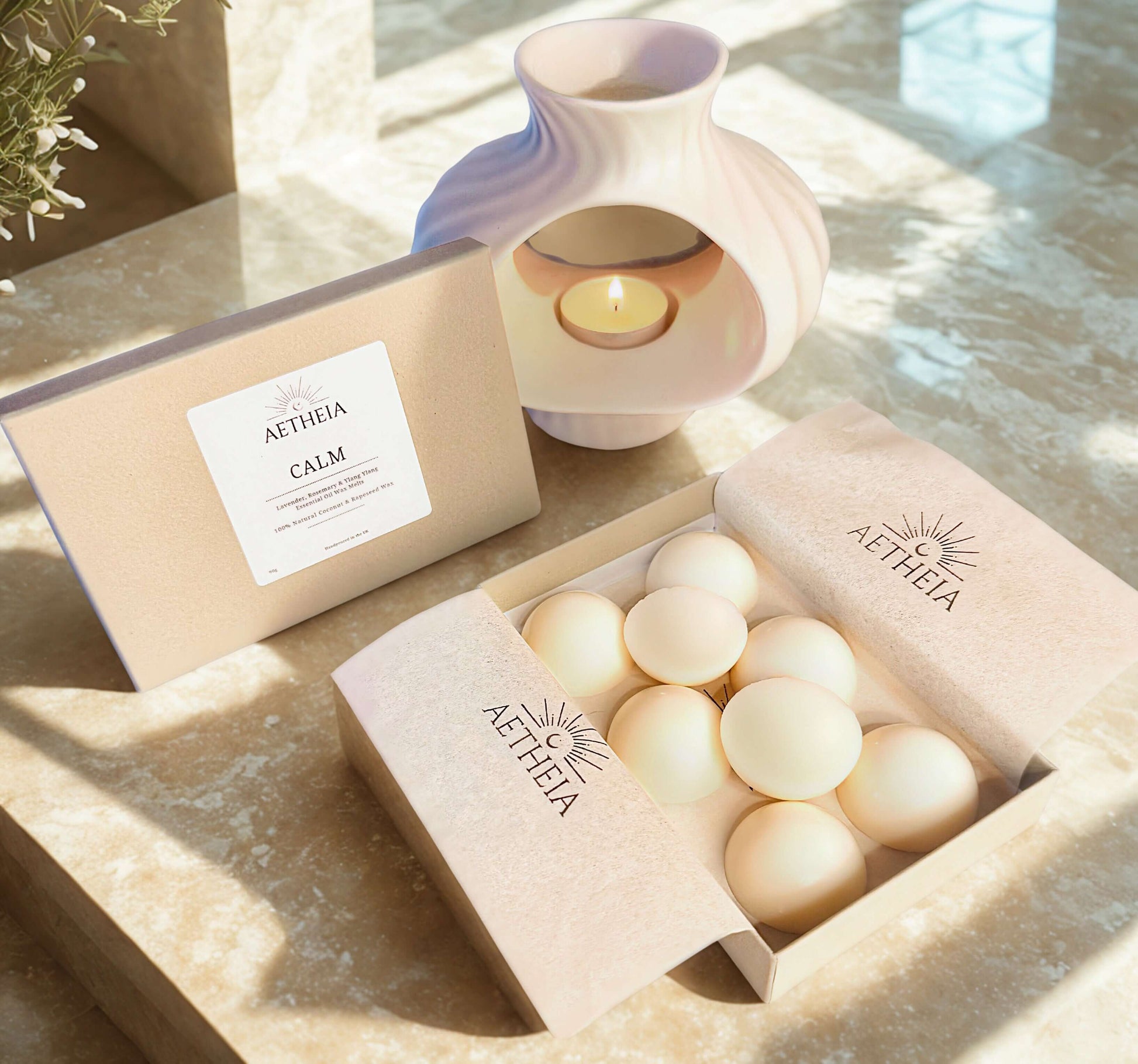 Atheia Calm wax melt box with white ceramic wax burner melting wax melts using small candle on a marble surface