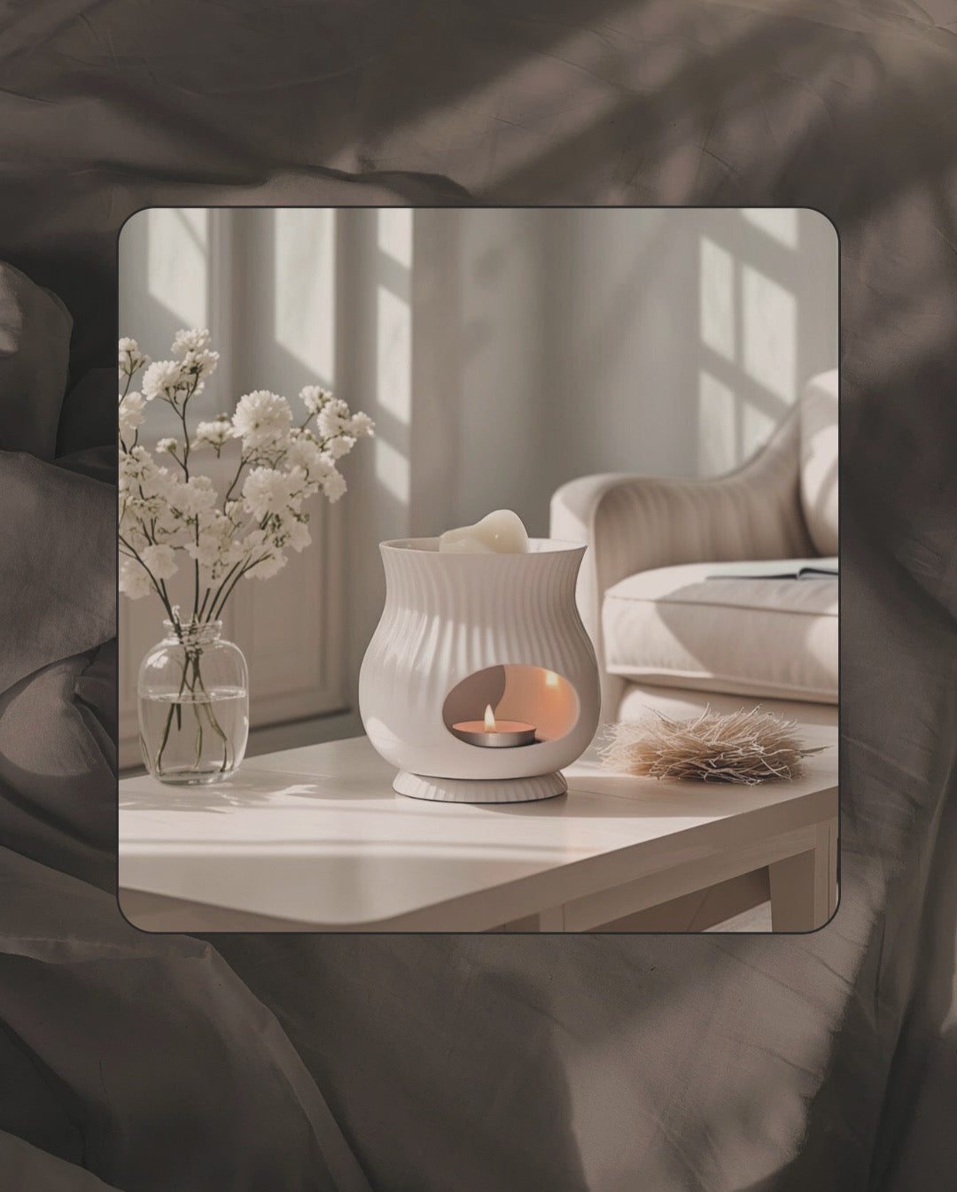 White ceramic wax melt burner with candle warming wax melts scene with a vase of flowers on a table in a softly blurred room setting.