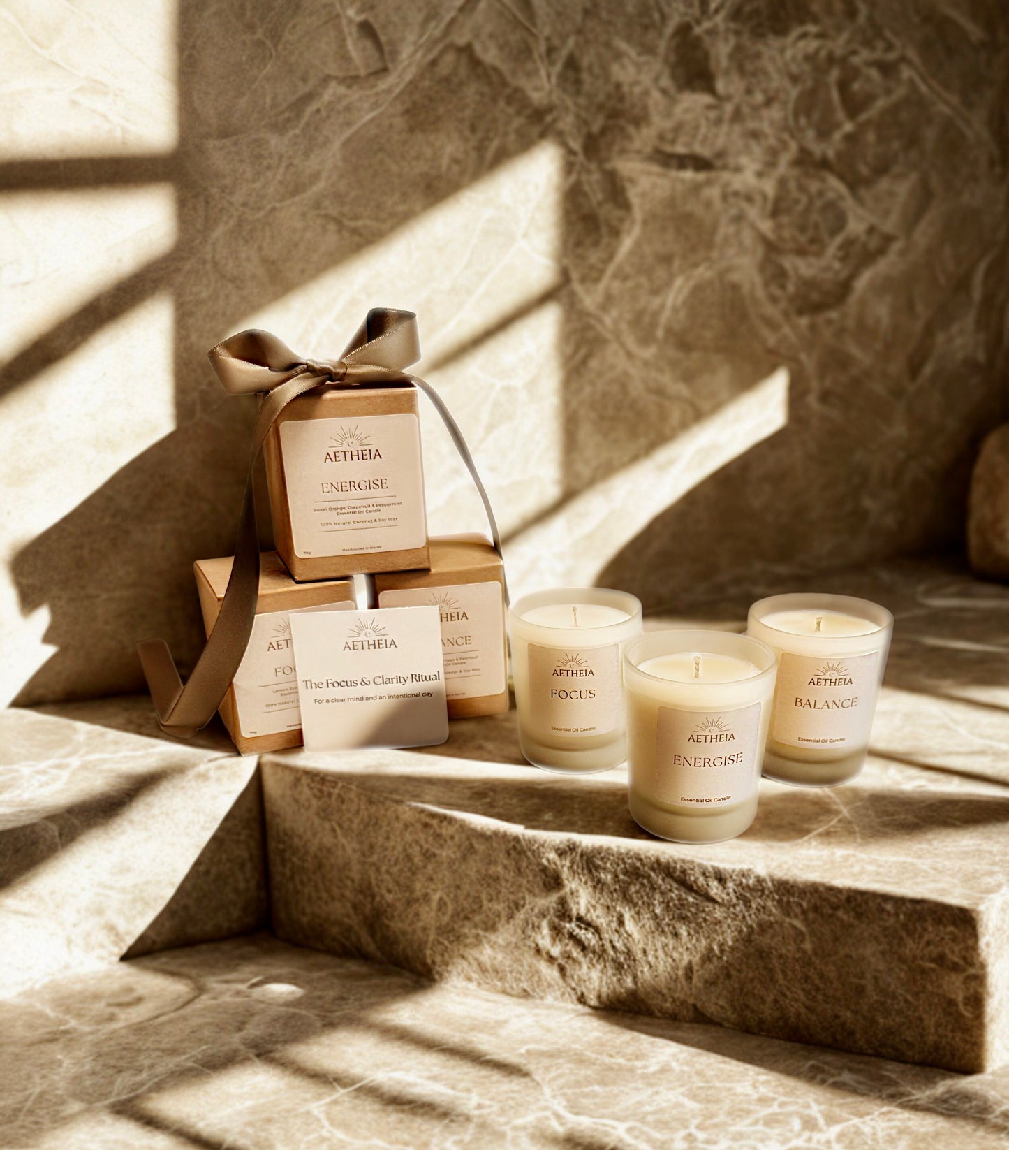 Aetheia discovery set candles and boxes on a stone surface with sunlight casting shadows.